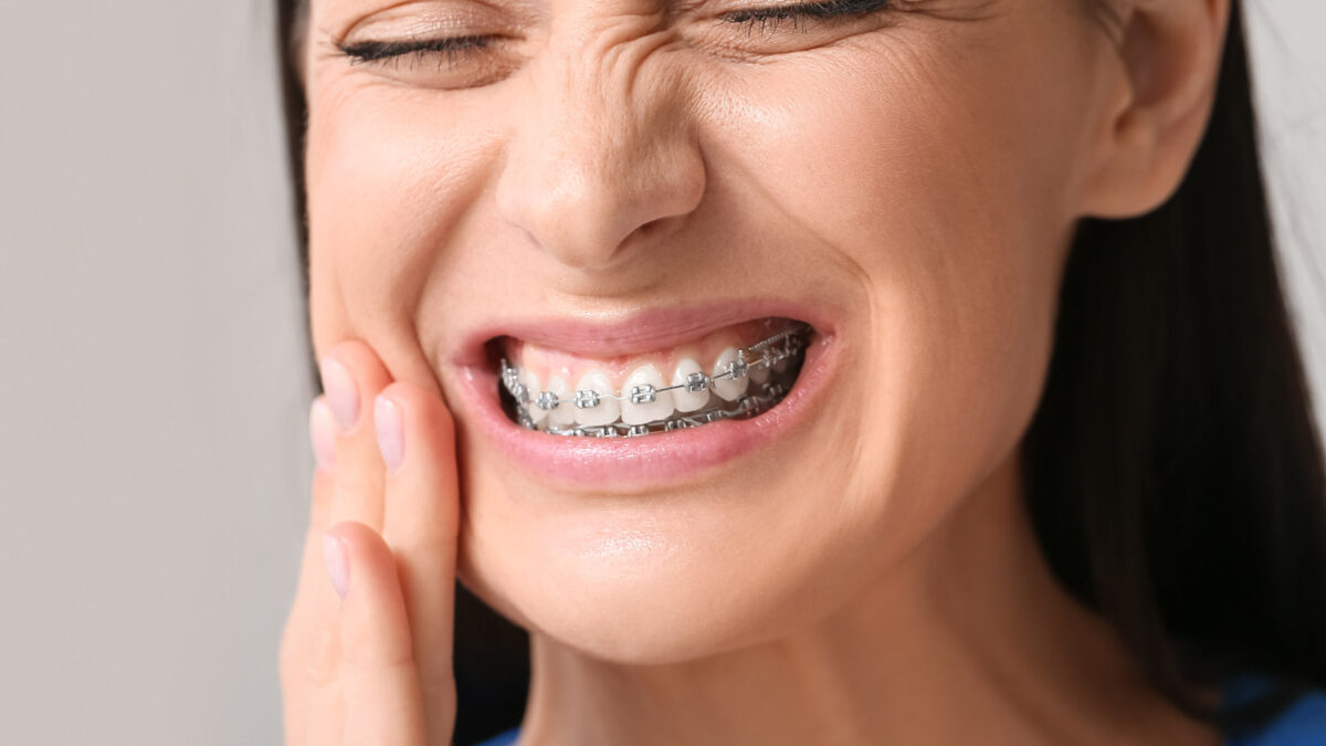 a woman with braces suffering from toothache