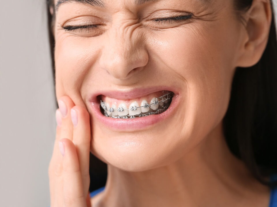 a woman with braces suffering from toothache