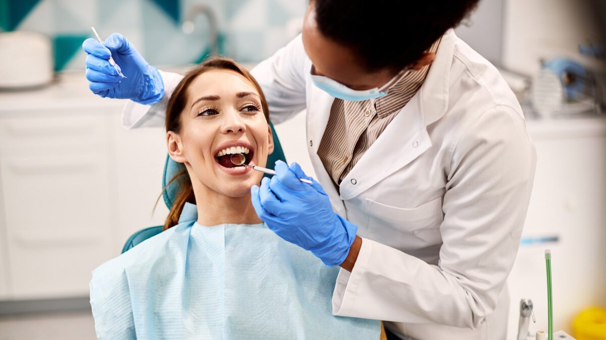 Woman getting dental examination by a female dentist