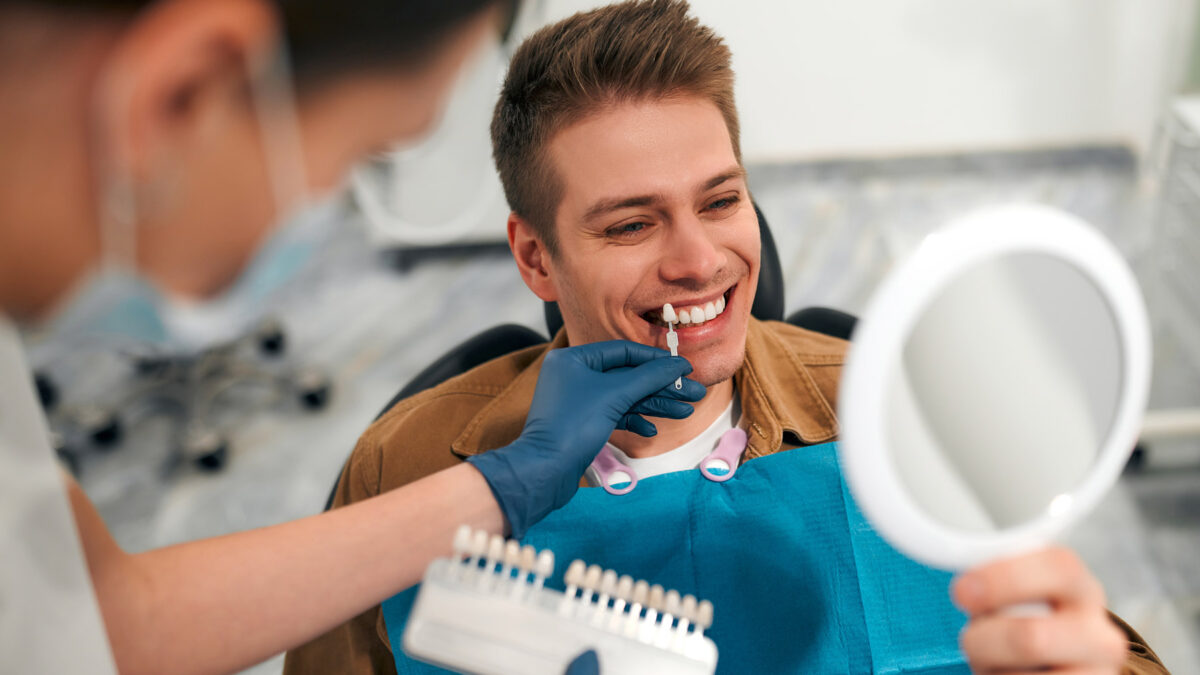 young attractive man smiling and choosing his custom made dental veneers at Aria Dental