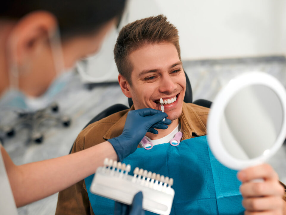 young attractive man smiling and choosing his custom made dental veneers at Aria Dental