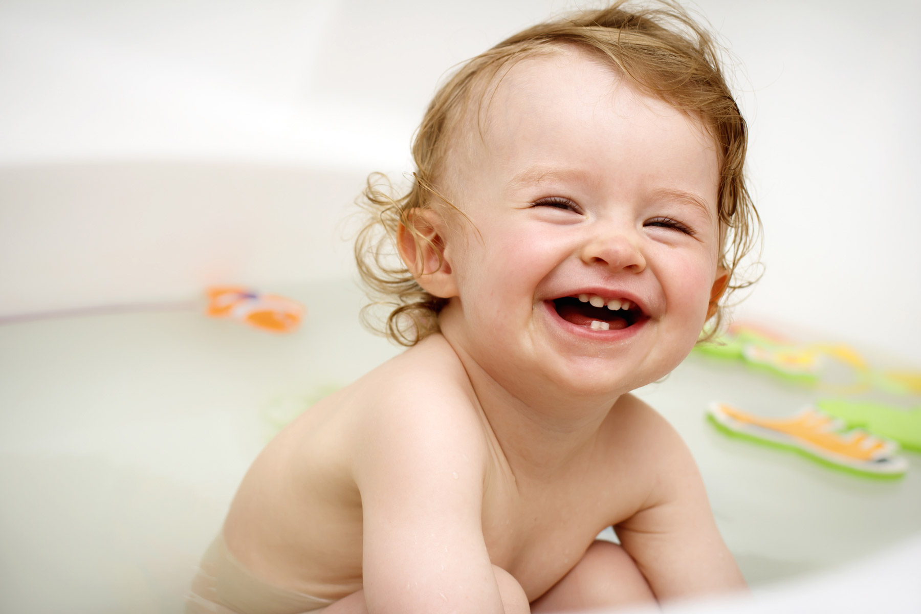 a baby laughing in bath tub