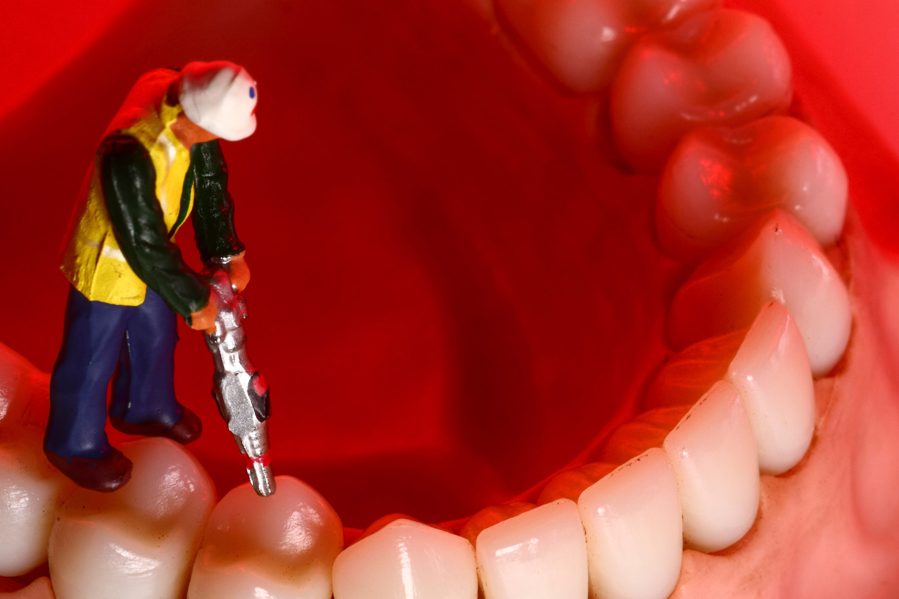 a miniature toy man drilling on a tooth