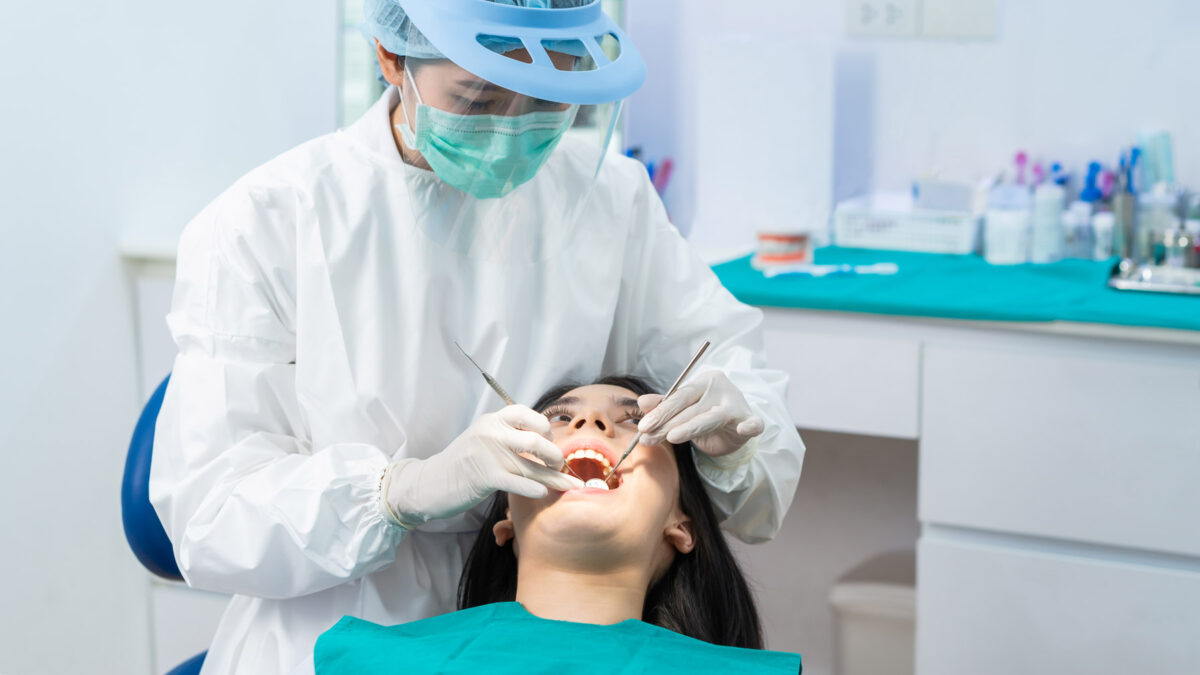 a dentist giving dental examination to a teenage female patient