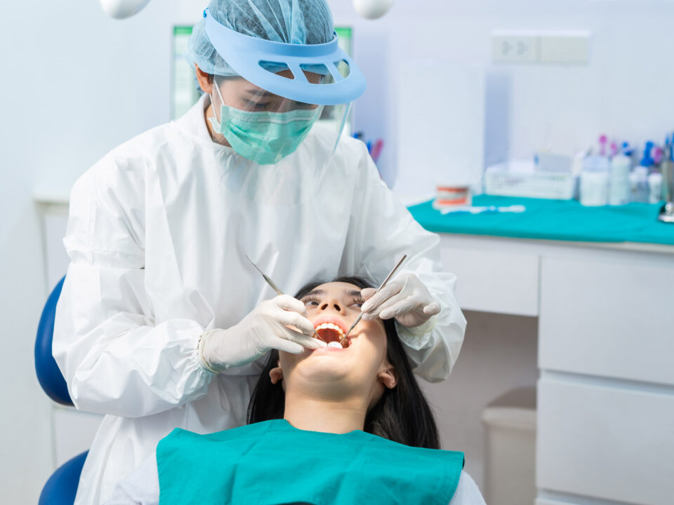a dentist giving dental examination to a teenage female patient