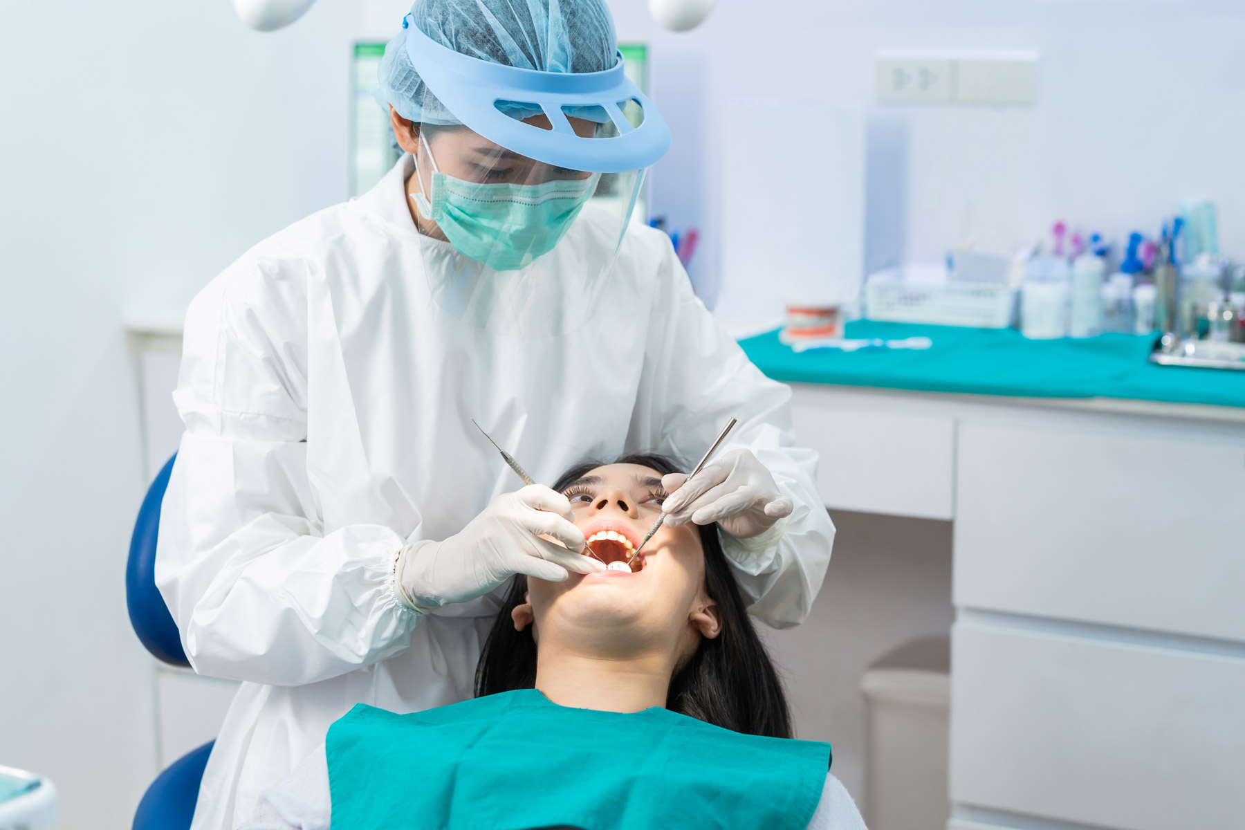 a dentist giving dental examination to a teenage female patient