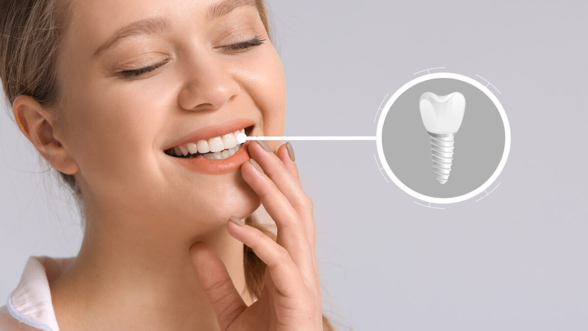 young happy female patient with a dental implant