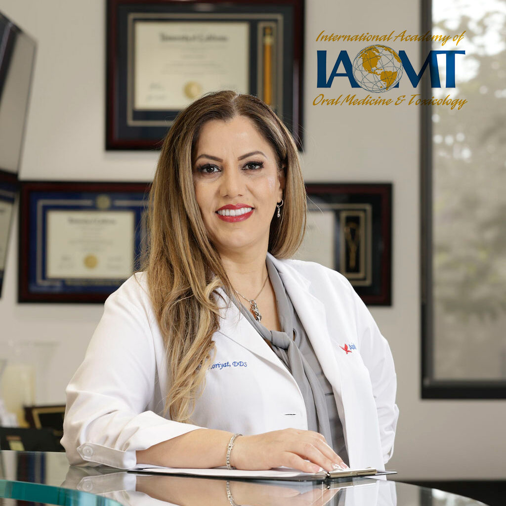 Can You Get a Same Day Tooth Extraction and Implant? 2 Dr. Maryam Horiyat in the office with IAOMT logo on top right on the image