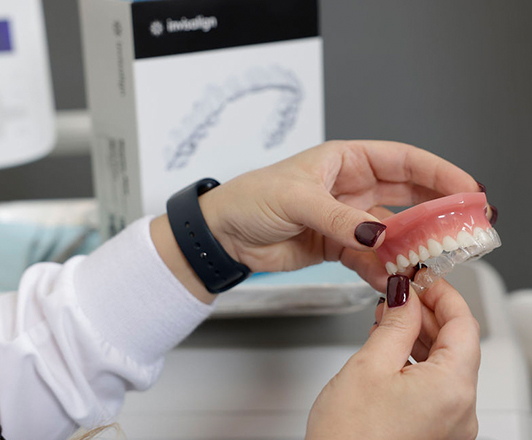 Dr. Maryam Horiyat putting Invisalign retainer on a teeth module