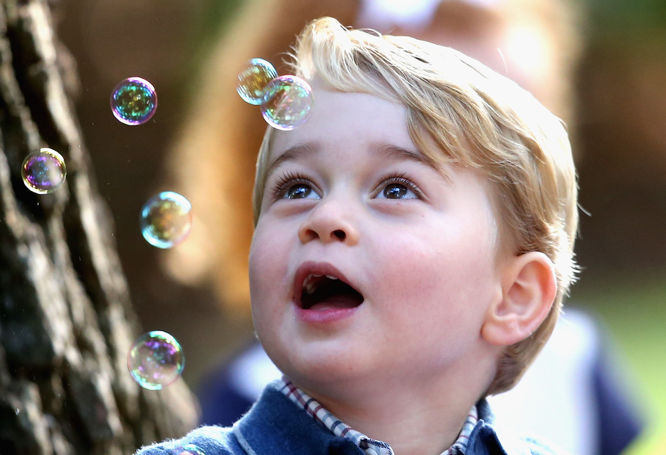 little boy amazed by bubbles in the air