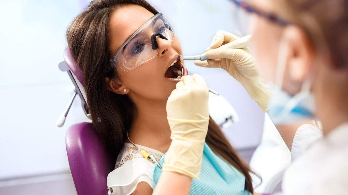 dentist performing root canal on a beautiful female patient