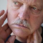 TMJ Face Distortion; the Ugly Side of a Disorder 4 close up of an old man holding his jaw with his hands